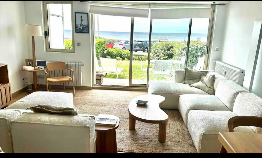 uma sala de estar com um sofá e vista para o oceano em Le Touquet Beach, Front de Mer em Le Touquet-Paris-Plage
