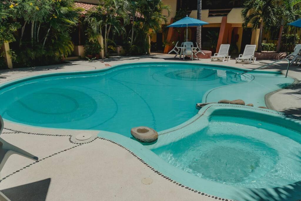 een zwembad met blauw water in een resort bij Casabu in Zihuatanejo