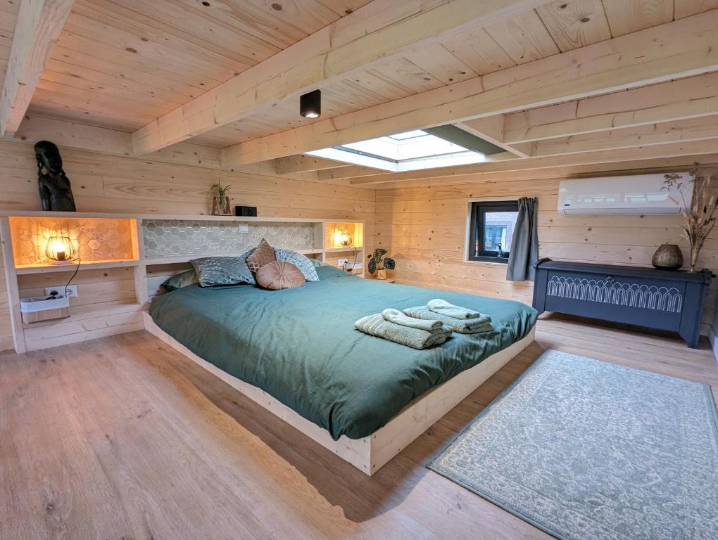 ein Schlafzimmer in einem Blockhaus mit einem Bett in der Unterkunft Klavertje 4 in Middelaar
