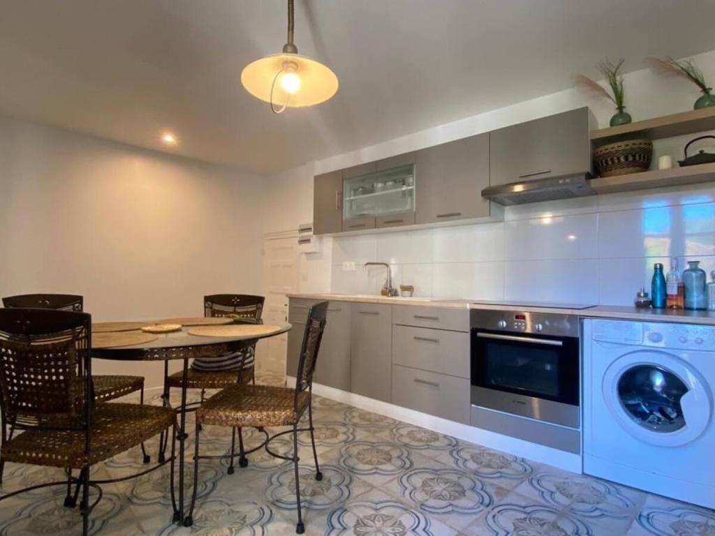 eine Küche mit einem Tisch und einer Waschmaschine in der Unterkunft Appartement moderne T3 duplex in Le Boulou