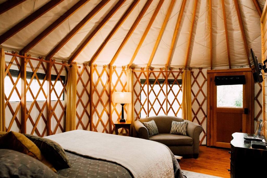 a room with a bed and a chair in a yurt at Tuckaseegee @ Sky Ridge Yurts in Bryson City