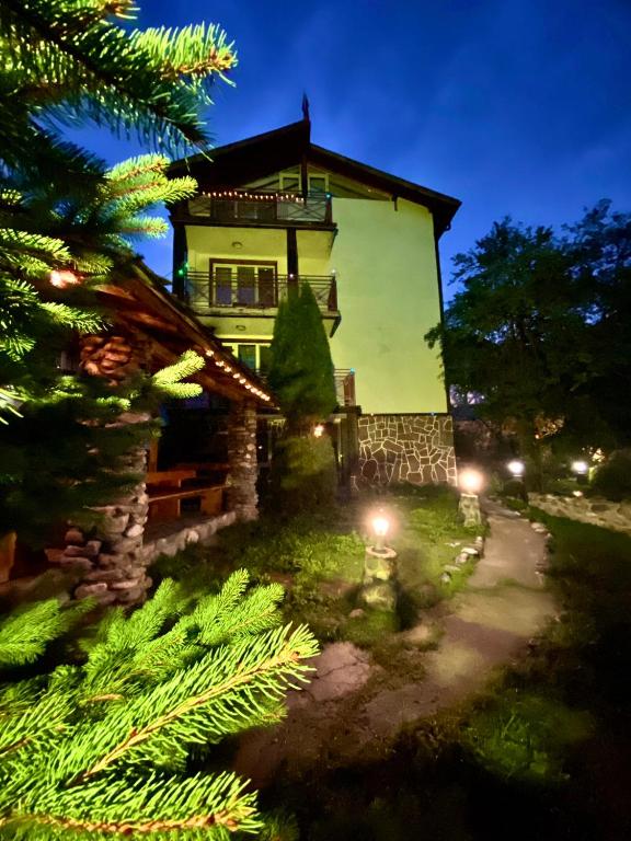 a house with a christmas tree in front of it at КЪЩА ЗА ГОСТИ ВОДЕНИЦАТА in Devin