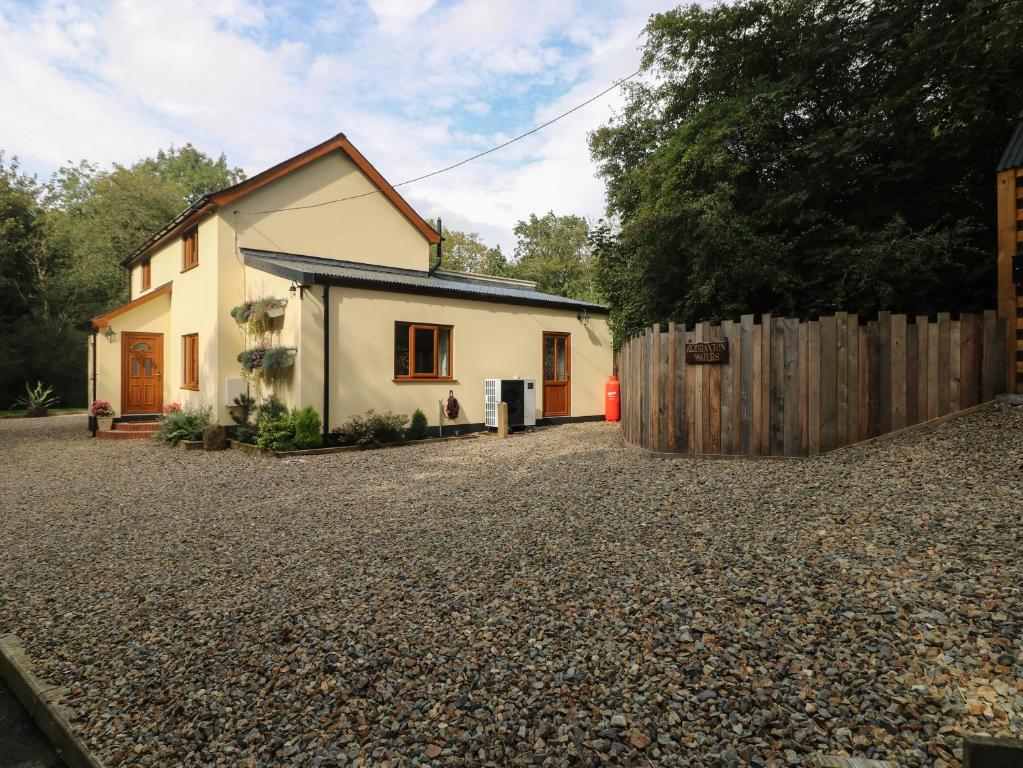 una casa con valla y entrada de grava en Rudbaxton Water, en Haverfordwest