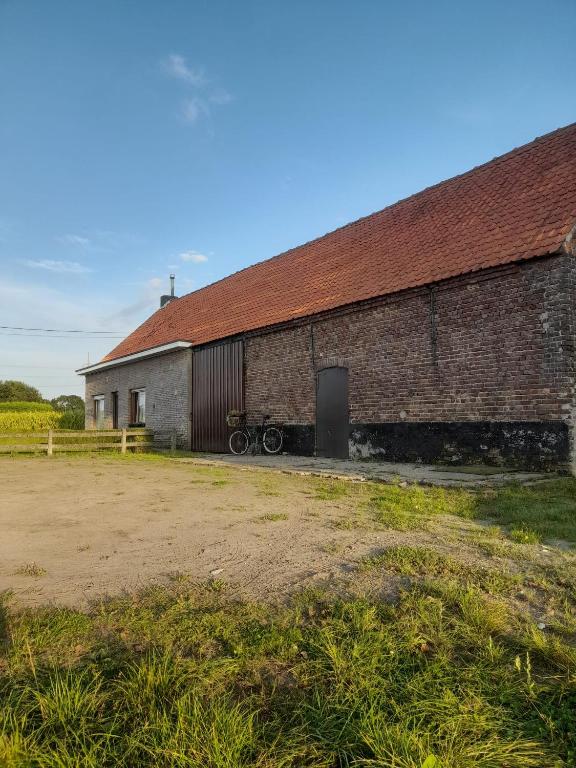 a brick building with a wagon parked in front of it at In the old farmhouse in Assenede