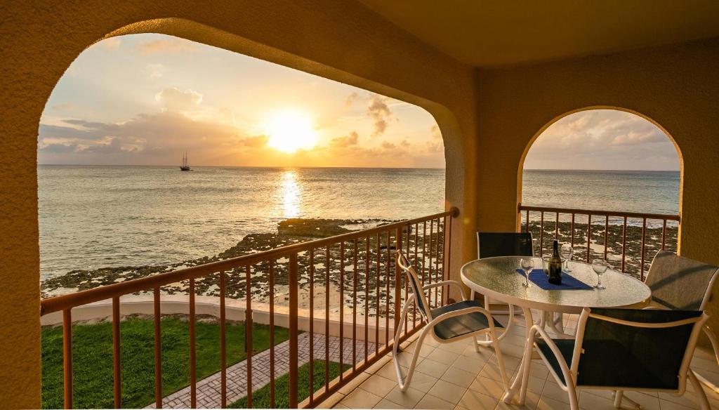 balcón con mesa y vistas al océano en Georgetown Villas #201, en George Town