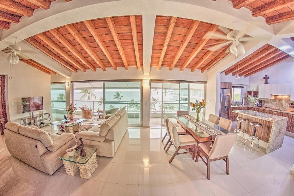 ブセリアスにあるCosta Dorada - Beachfront Penthouse in Bucerias Golden Zoneのテーブルと椅子のある広いリビングルーム