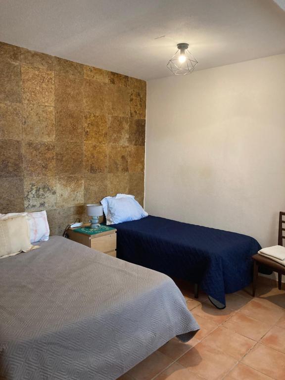 a bedroom with two beds and a chair at Casa Praia do Sul in Ericeira