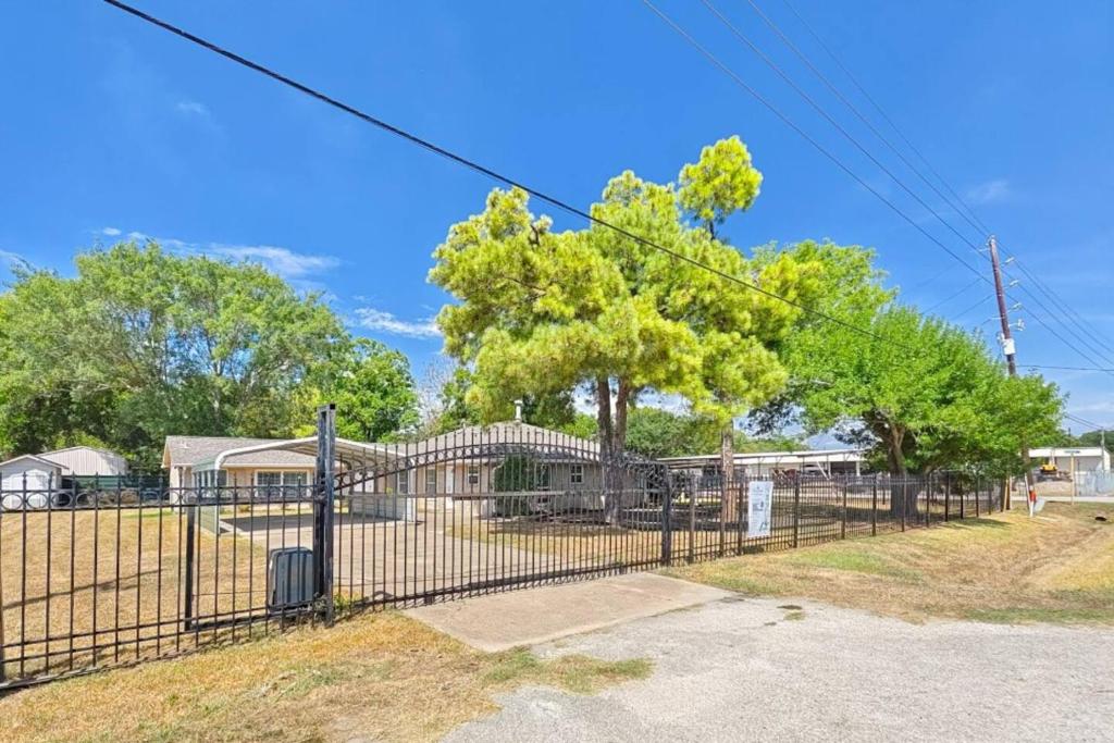 einen Zaun vor einem Haus mit einem Baum in der Unterkunft Tranquil Oasis in Houston