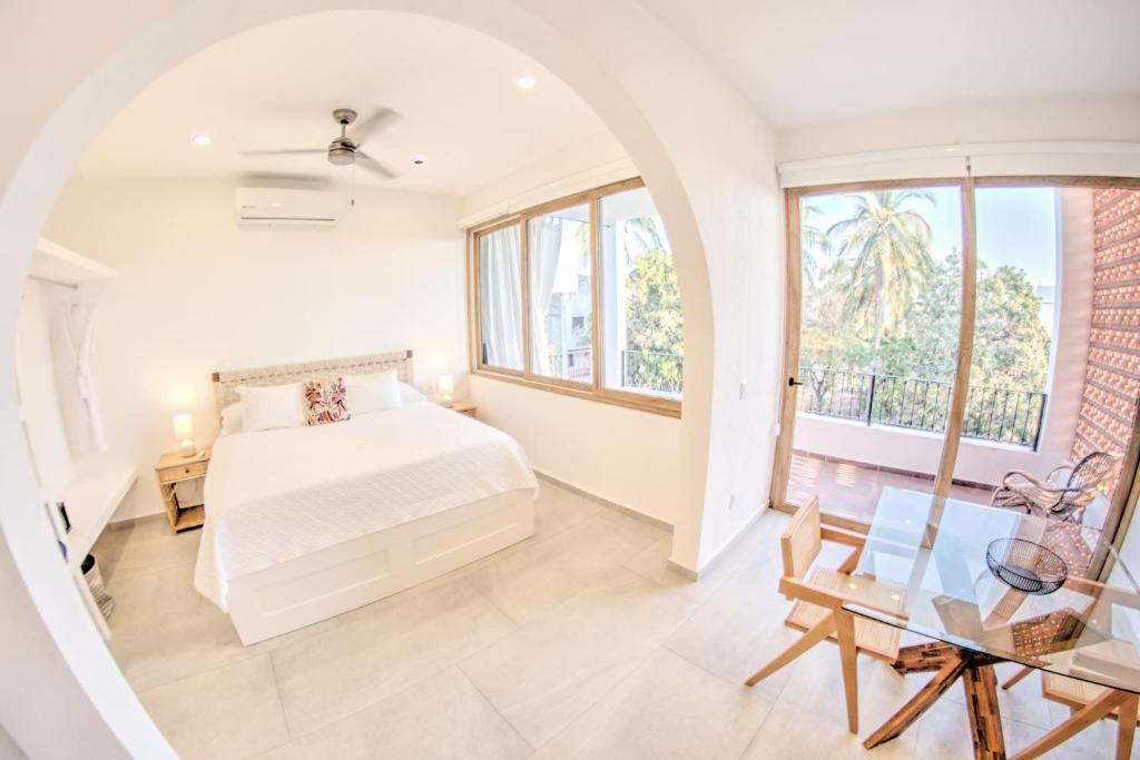 - une chambre avec un lit et une grande fenêtre dans l'établissement Estadios Suites - Only 3 Blocks to Beach, à Bucerías