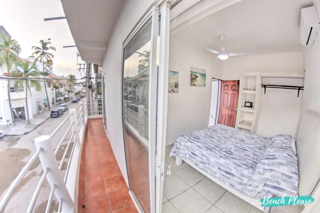 a bedroom with a bed and a balcony at Madison - 99 Steps to Beach in Golden Zone in Bucerías
