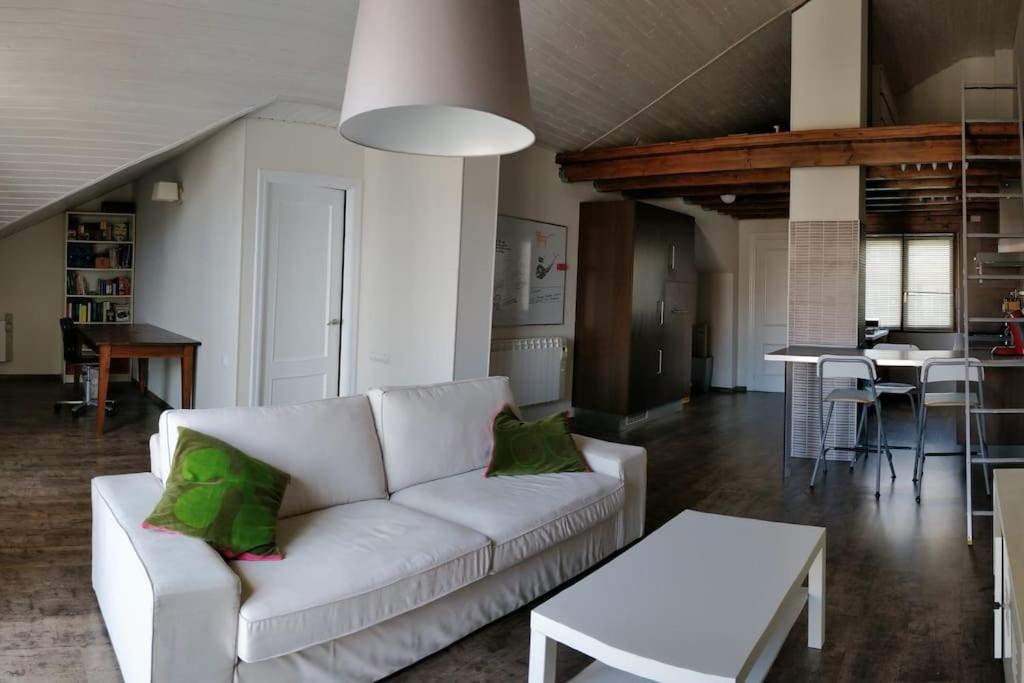 a living room with a white couch with green pillows at IAROS El Coto in Mogro