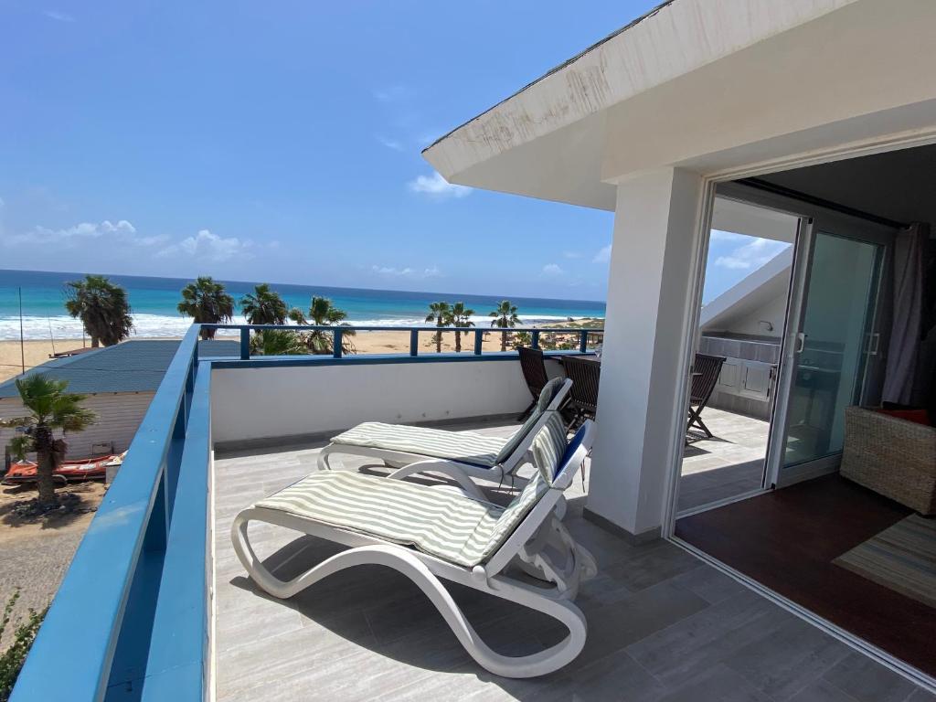 een stoel op een balkon met het strand op de achtergrond bij Leme Bedje Sea View Apartments with Pool in Santa Maria