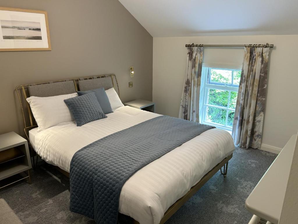 Irvinestown的住宿－Castle Irvine Estate，一间卧室设有一张大床和一个窗户。