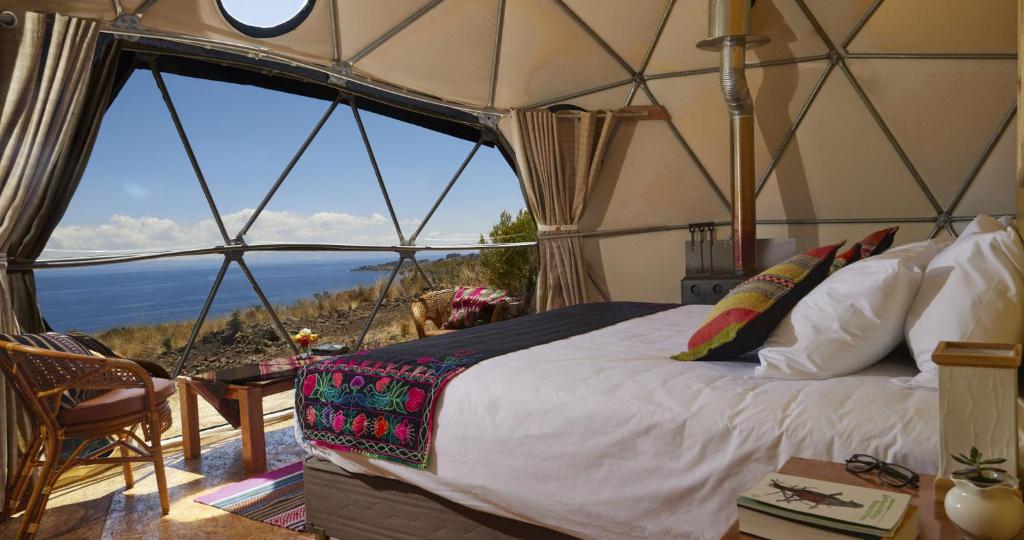 een slaapkamer in een yurt met uitzicht op de oceaan bij Titikaka Sky View in Juliaca