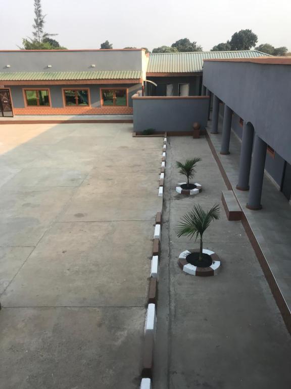 un edificio con dos palmeras en un aparcamiento en Awesome Executive Lodge, en Solwezi