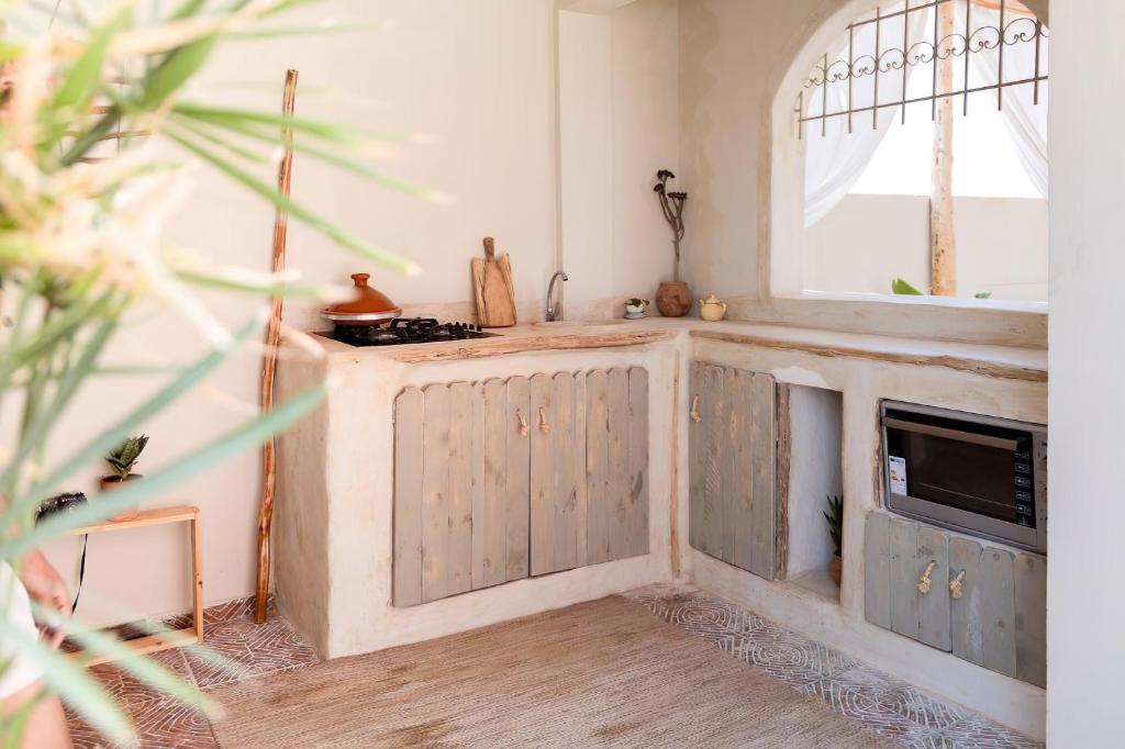 a kitchen with wooden cabinets and a sink and a mirror at Desart Hostel in Agadir