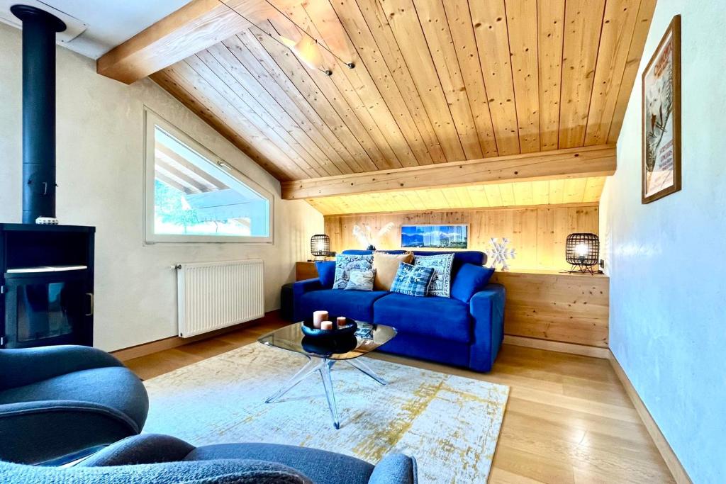 - un salon avec un canapé bleu et une cheminée dans l'établissement Perles des Alpes, à Combloux