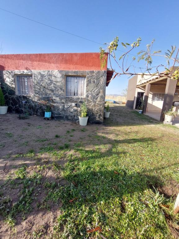 una casa de piedra con techo rojo y patio en Cabaña Villa Emocion in 