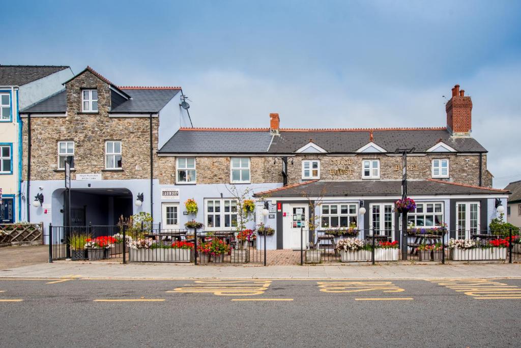 un gran edificio de ladrillo con puertas y ventanas blancas en The Coach House Hotel, en Pembroke