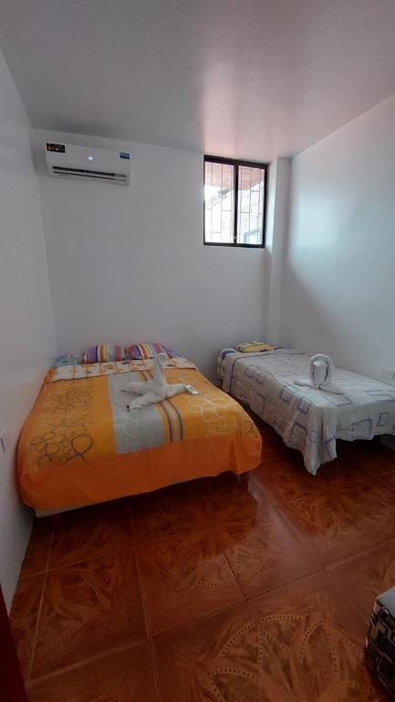 a room with two beds and a window at CASA DE NOELIA in Puerto Baquerizo Moreno