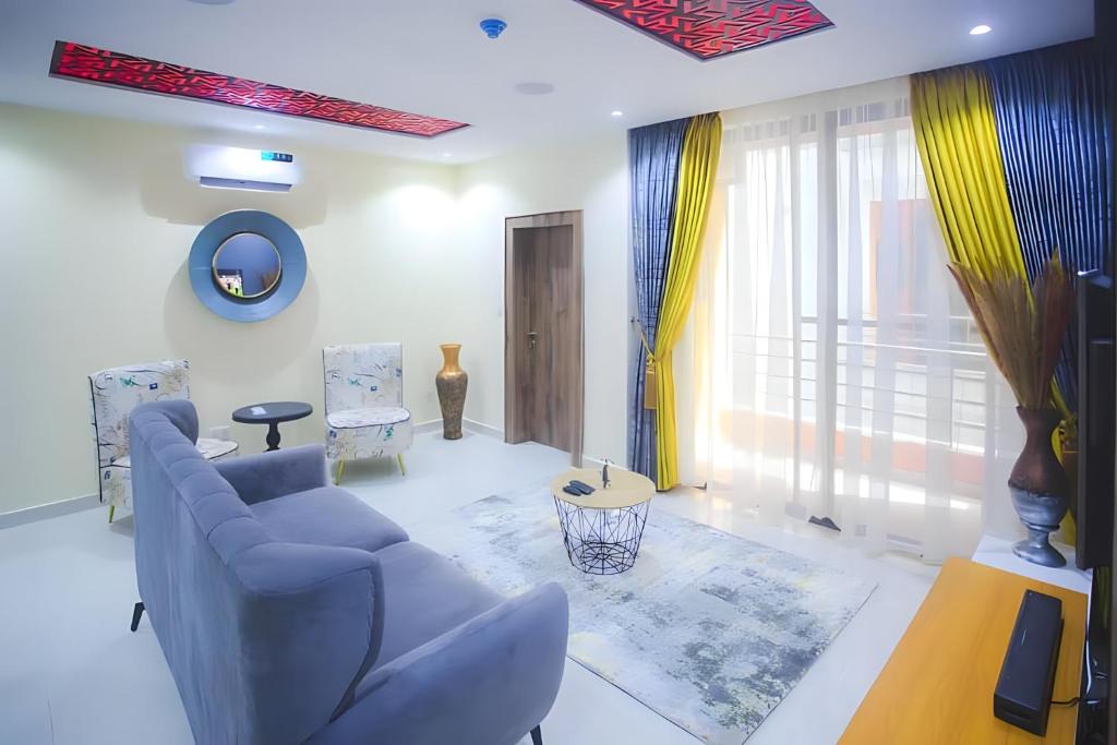 a living room with a blue couch and a window at Picturesque 3-bedroom Apartment in Yaba in Lagos
