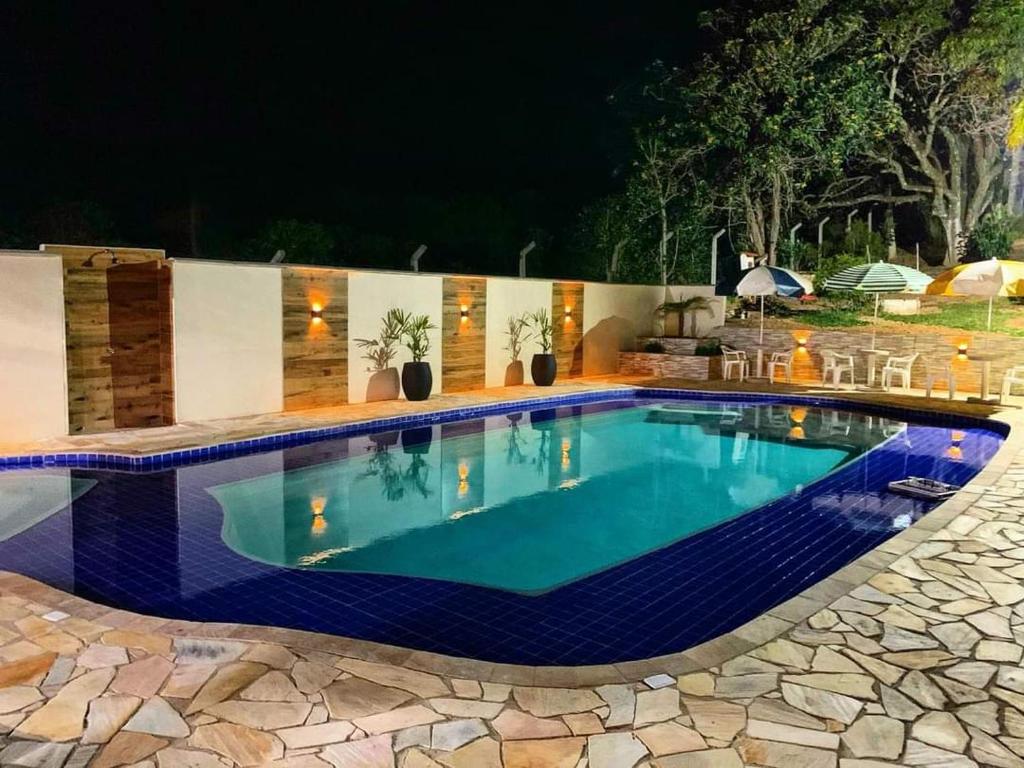 a swimming pool in a backyard at night at Chalé Alto da Serra SP in Serra Negra