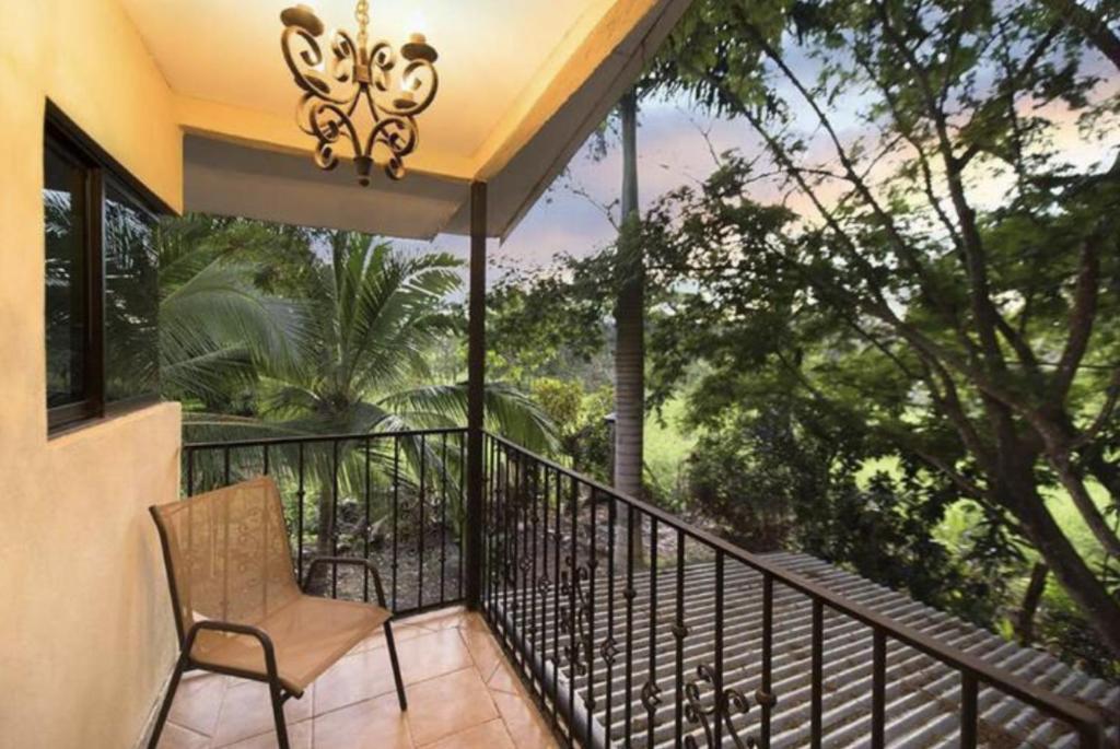 a chair on a balcony with a view of trees at Casa Selva in Cabuya