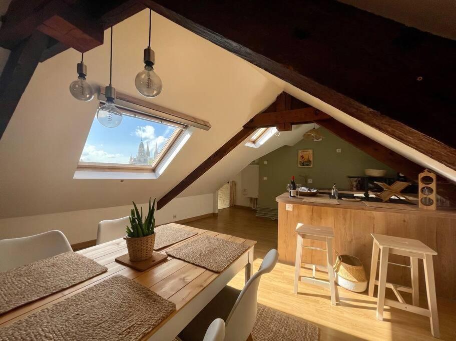 a kitchen and dining room with a table and chairs at La Bellevue x Parking by Melrose in Bayeux