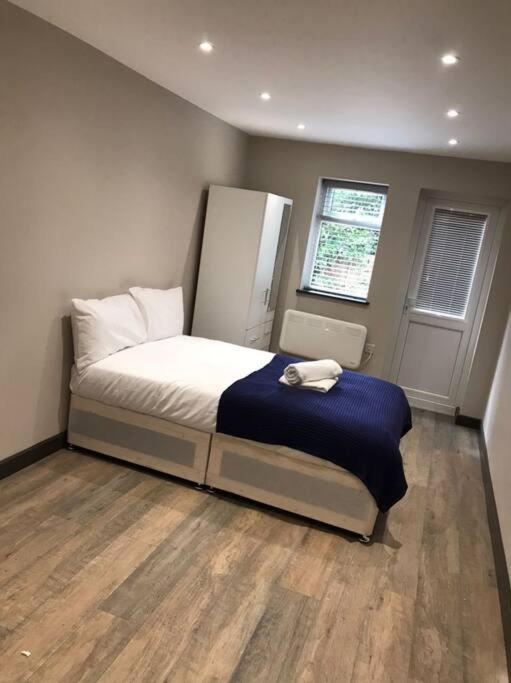 a bedroom with a bed with a blue blanket at Bedfont House in New Bedfont