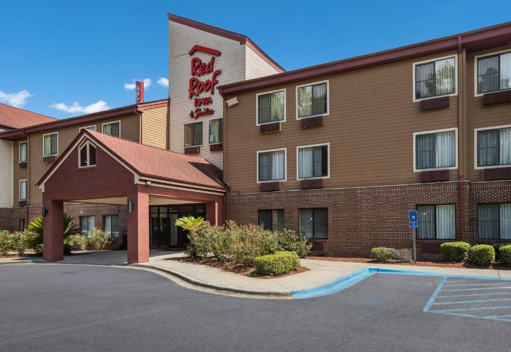 un hotel con un estacionamiento delante de él en Red Roof Inn & Suites Savannah Airport en Savannah