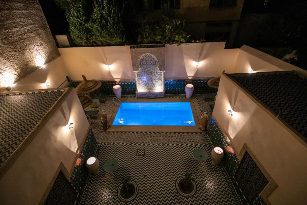 una vasca idromassaggio all'aperto con luci sul patio di notte di Riad Fes Ziyat & Spa a Fes