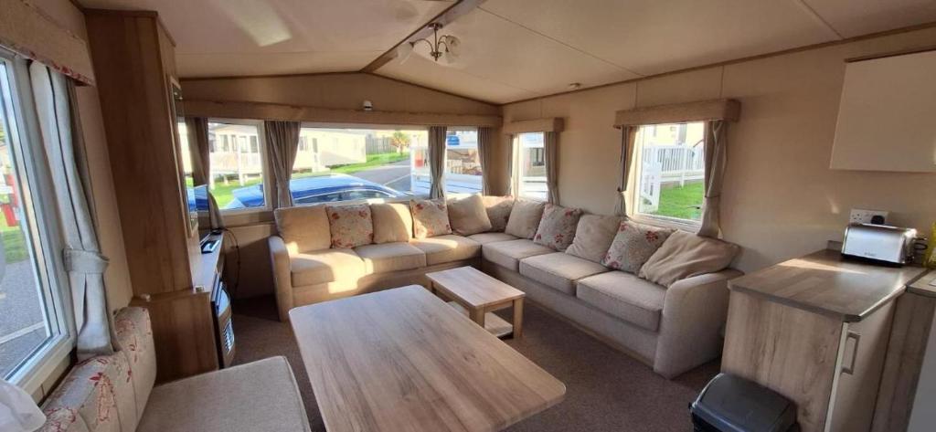 a living room with a couch and a table at NB166 - Porth Bay Hideaway in Porth
