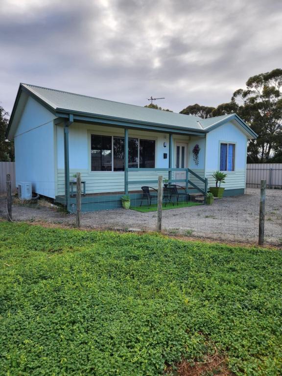 a blue house with a yard in front of it at Taylor Cottage 