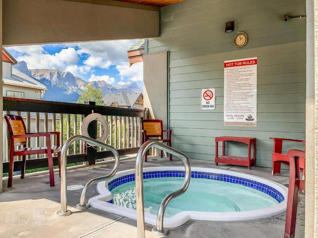 a hot tub on the patio of a house at 2BR Condo in Canmore [Pool, 3 Hot Tubs, Gym & BBQ] in Canmore