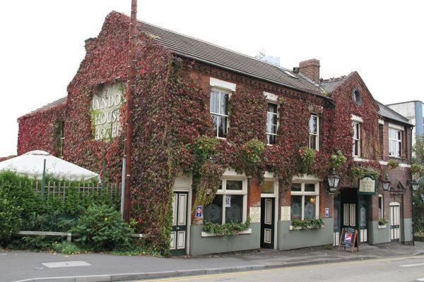 a brick building with ivy on it on a street at Lyndon House in Walsall