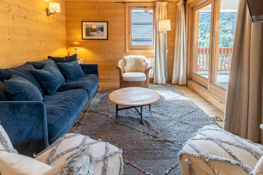 un salon avec un canapé bleu et une table dans l'établissement Cybèle 2, à Méribel