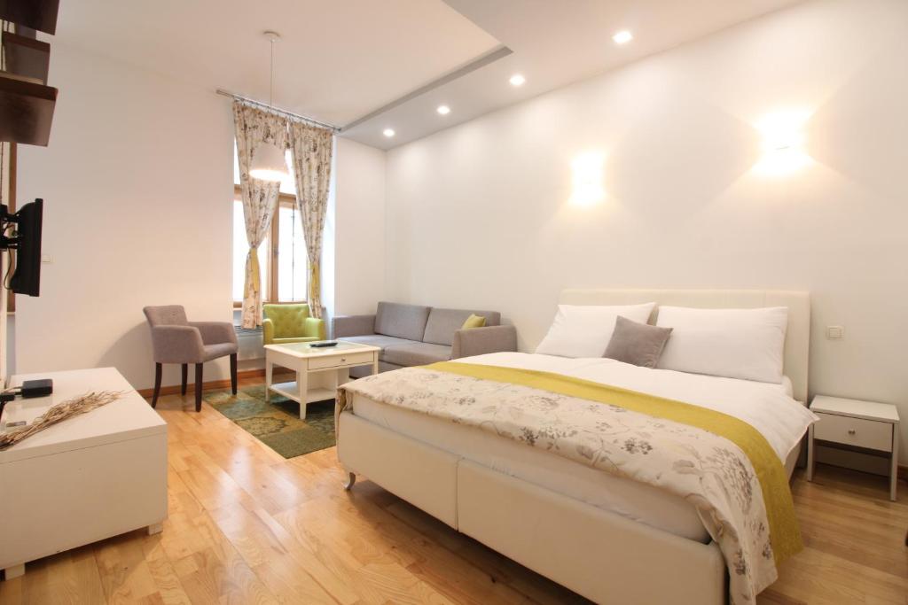 1 dormitorio con cama, sofá y mesa en City Studio Apartment, en Sarajevo