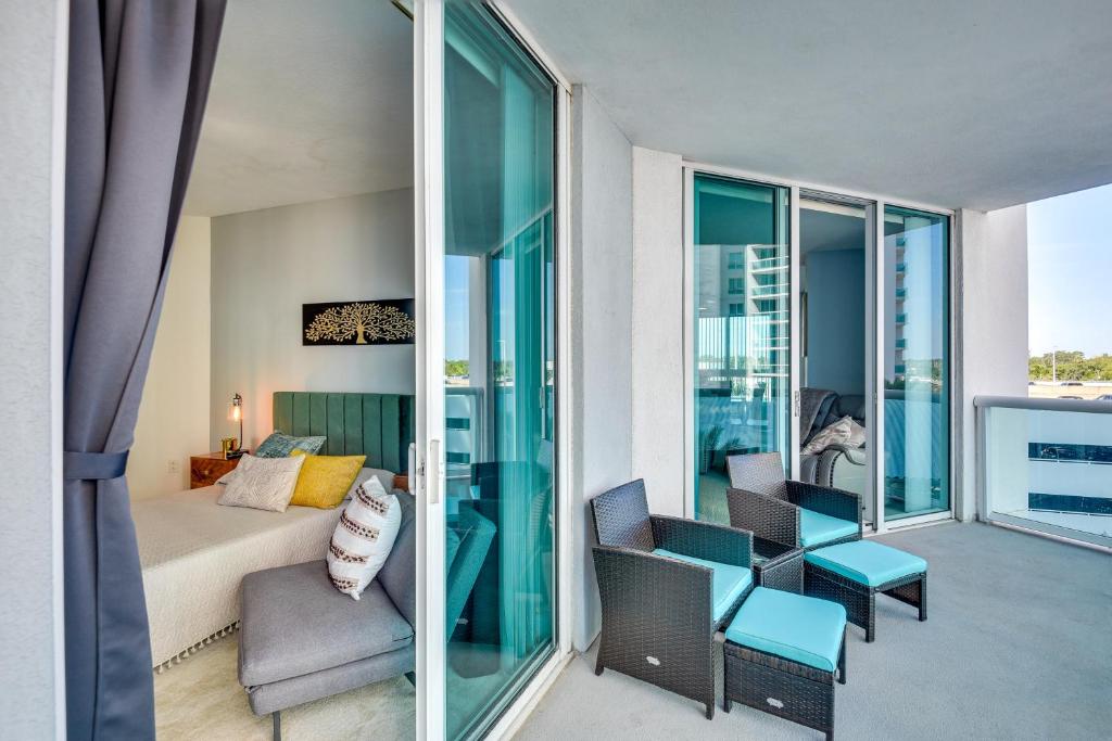 1 dormitorio con balcón con 1 cama y sillas en Luxe Resort Condo - 2 Mi to Daytona Beach! en Holly Hill