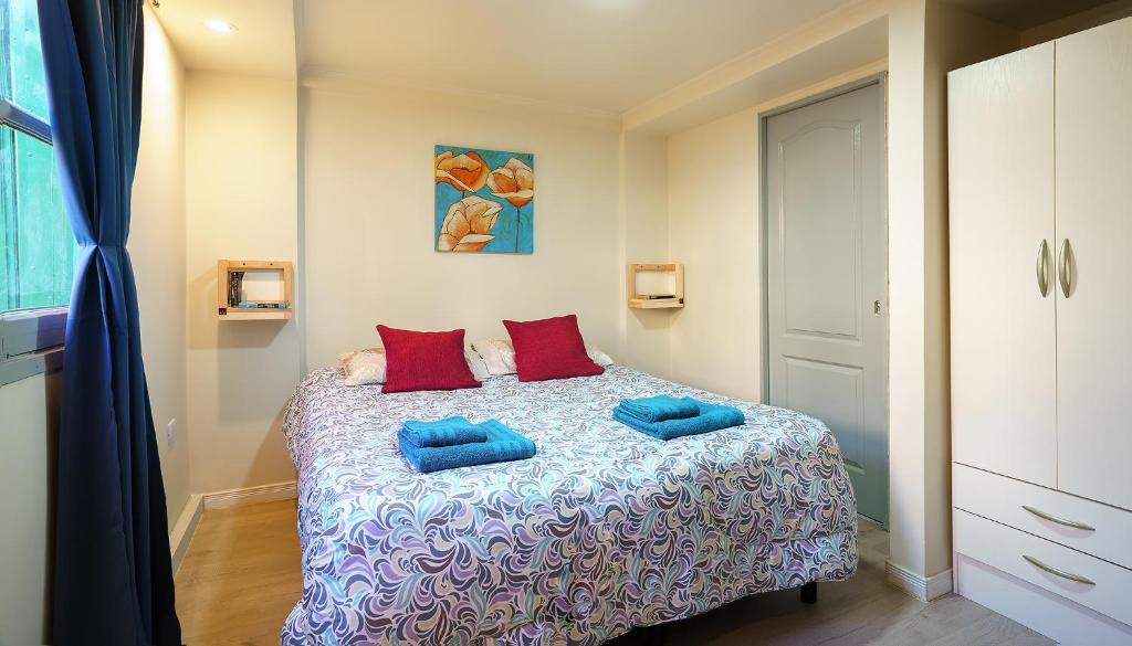 Un dormitorio con una cama con almohadas azules. en Amanecer de la Bahía en Ushuaia