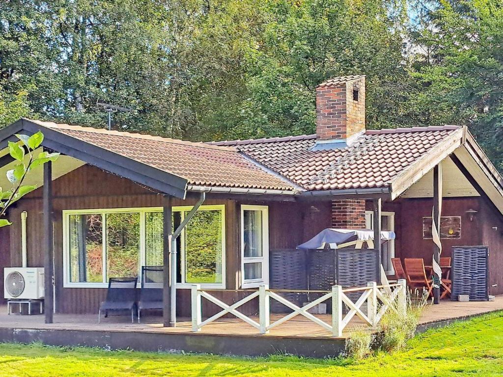 a small house with a porch and a brick chimney at Holiday home Frederiksværk XXIV in Frederiksværk