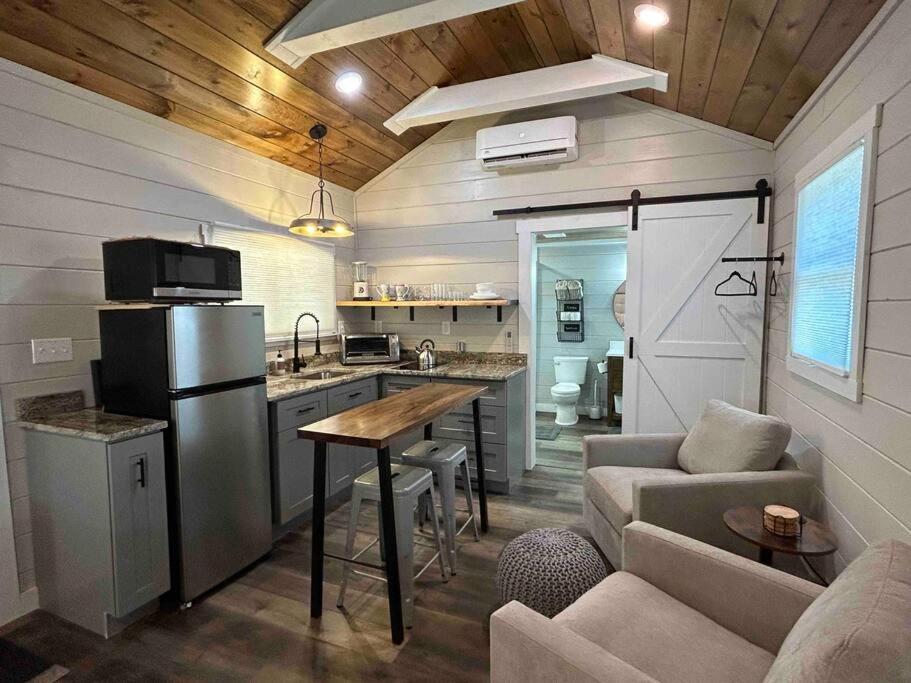 a kitchen and living room in a tiny house at Blissful Nook Tiny Home ~ Cozy Retreat w/ Hot Tub; near Town and Deep Creek in Bryson City