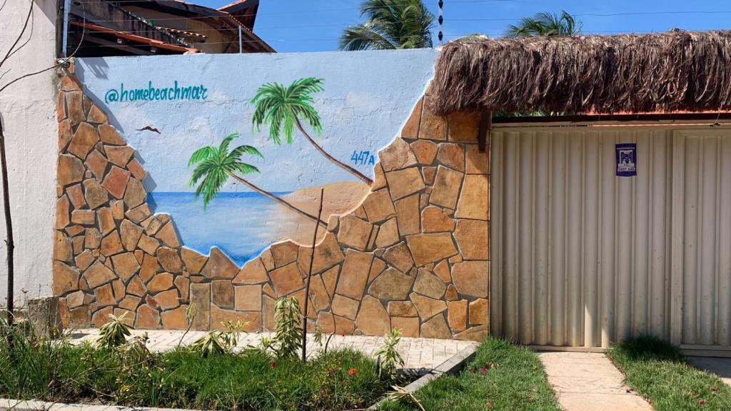 un muro con un murale raffigurante una spiaggia e palme di Pousada HOME BEACH MAR porto das dunas BEACH PARK ad Aquiraz