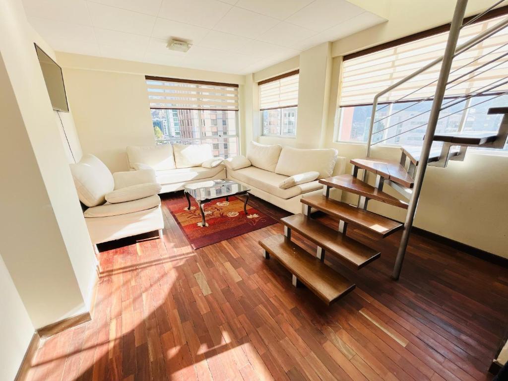 uma sala de estar com um sofá e uma mesa em Confortable y Amplio Apartamento Duplex en zona céntrica de Calacoto em La Paz