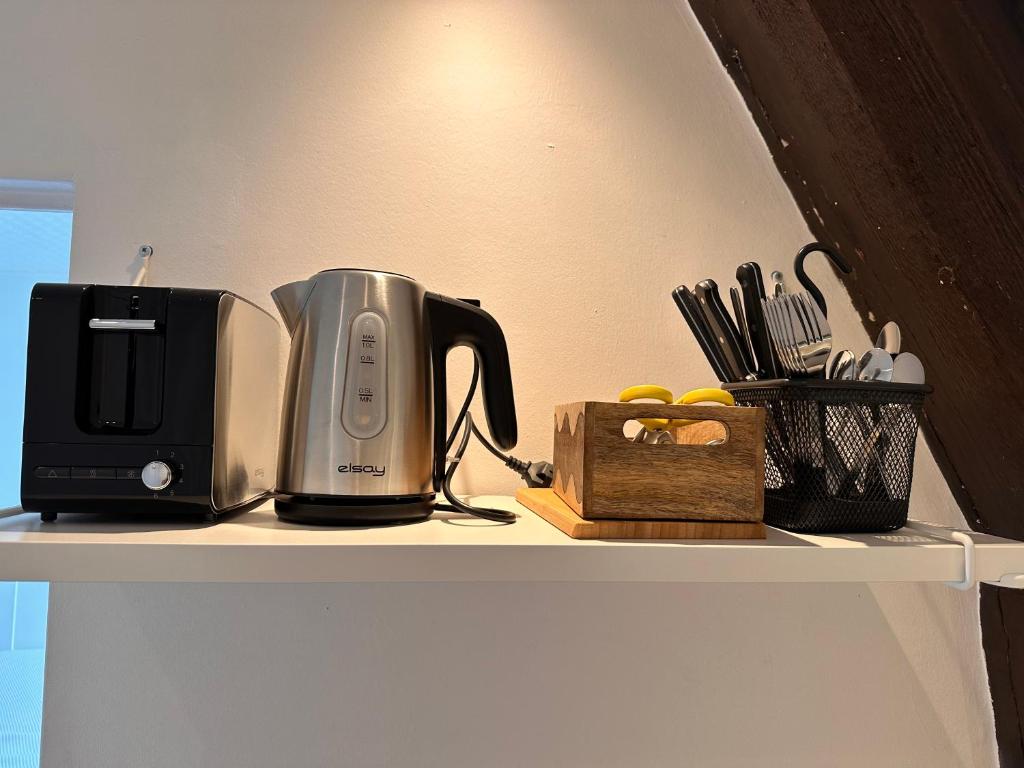 a coffeemaker and a toaster sitting on a shelf at Le Petit Port in Sedan