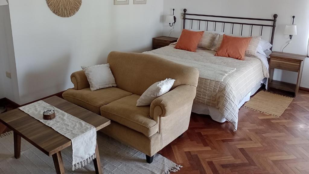 1 dormitorio con cama, sofá y mesa en Nueva Morada en Córdoba