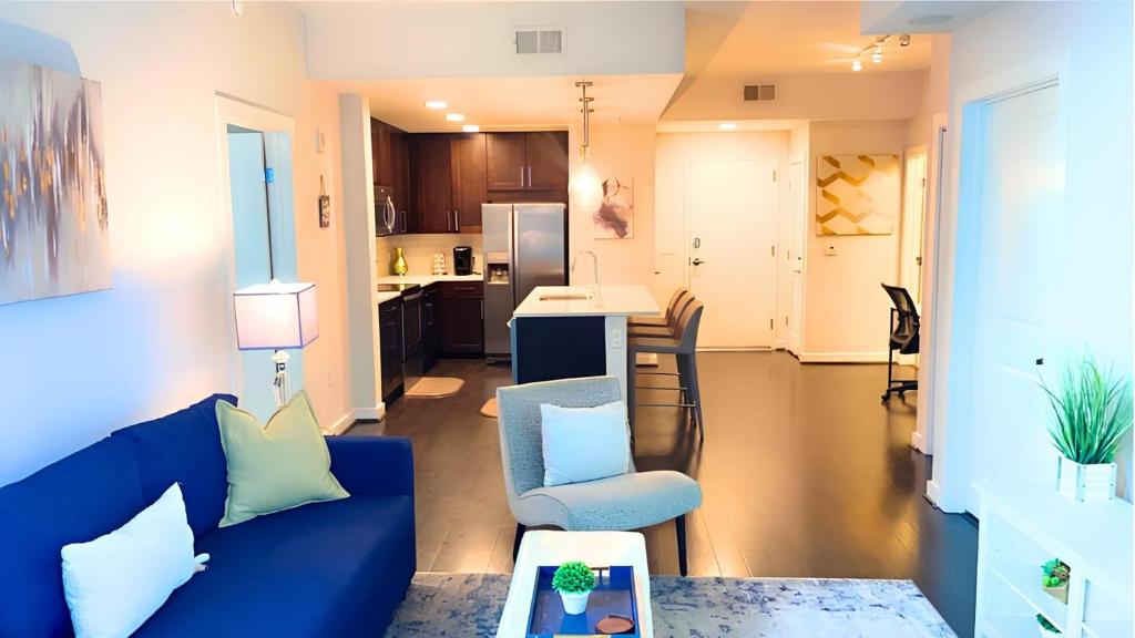 a living room with a blue couch and a kitchen at Blue Luxe-Highrise, Balcony, Pool, City View! in Atlanta