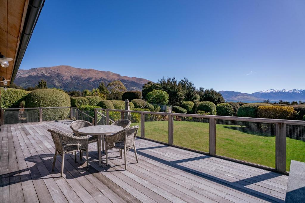 a wooden deck with a table and chairs on it at Hāwea Lakehouse - Lake Hāwea Holiday Home in Lake Hawea