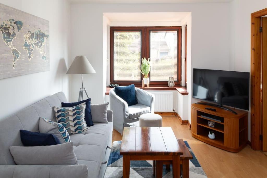 a living room with a couch and a tv at Executive Apartment By Inverkeithing Train Station in Fife