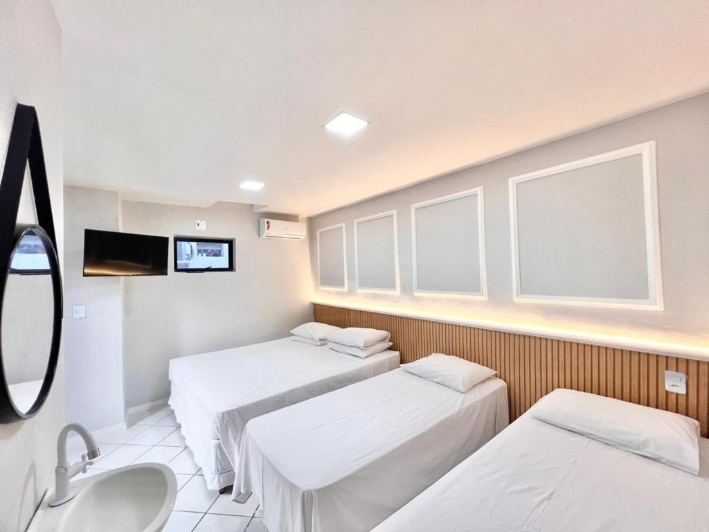 Habitación hospitalaria con 3 camas y lavamanos en POUSADA BEIRA MAR, en Fortaleza