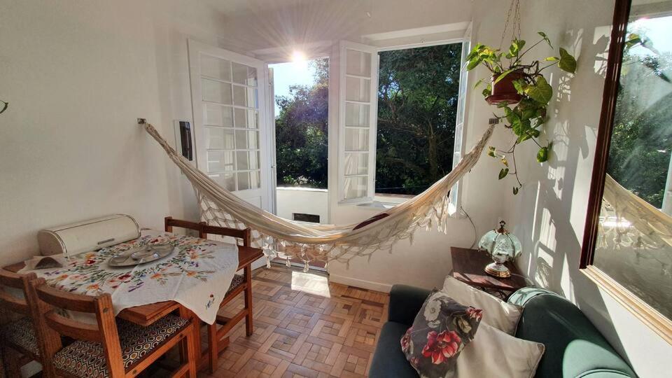 een kamer met een tafel en een hangmat. bij Casa da vovó Alba in Porto Alegre